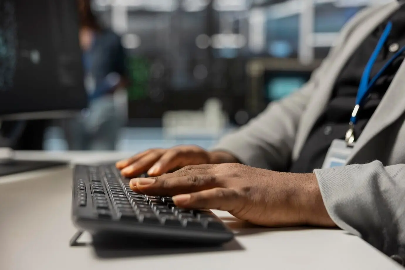 Nahaufnahme eines Rechenzentrums-Technikers, der auf einer Tastatur tippt und die Ausrüstung inspiziert.